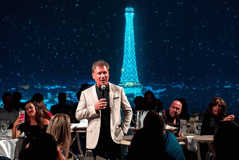 Dr. A speaking at a Coach dinner party.