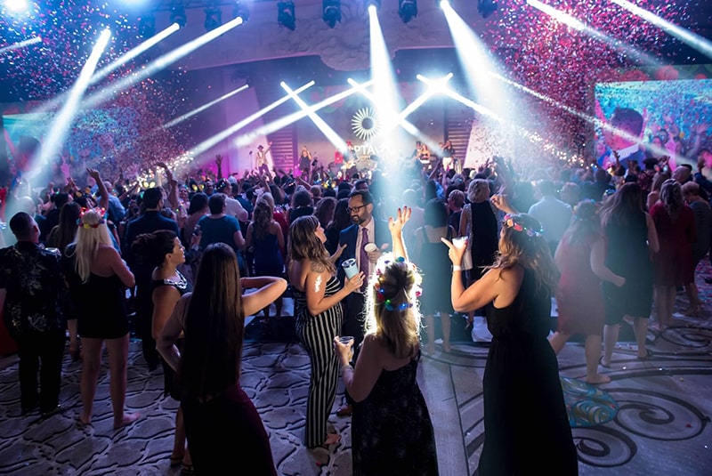 Crowd celebrating at the Celebration of Success After Aarty while a band performs on stage.