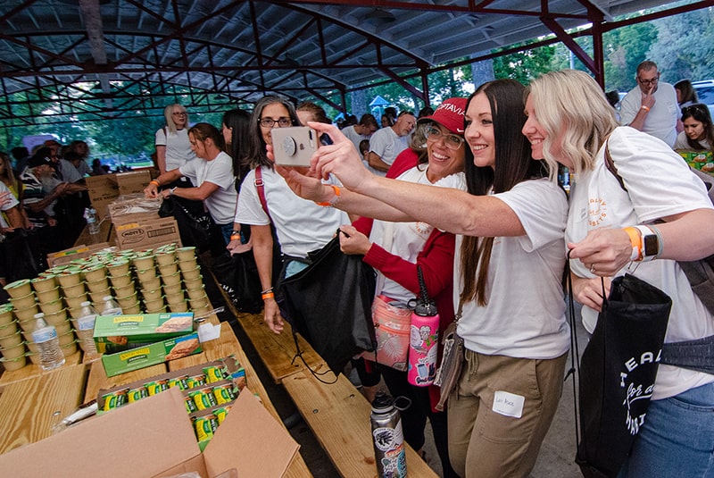 Volunteers preparing backpacks for donation to school children.