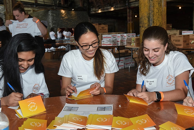 Volunteers signing cards for school children.