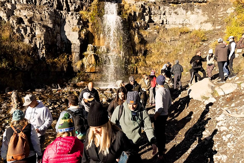 Coaches in front of a waterfall at Stewart Falls.