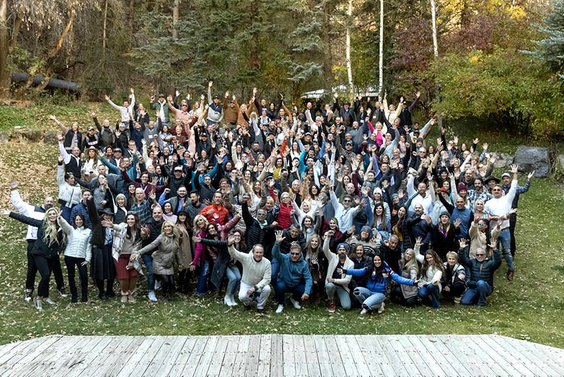 Group shot of all Sundance attendees outside, smiling with hands in the air.